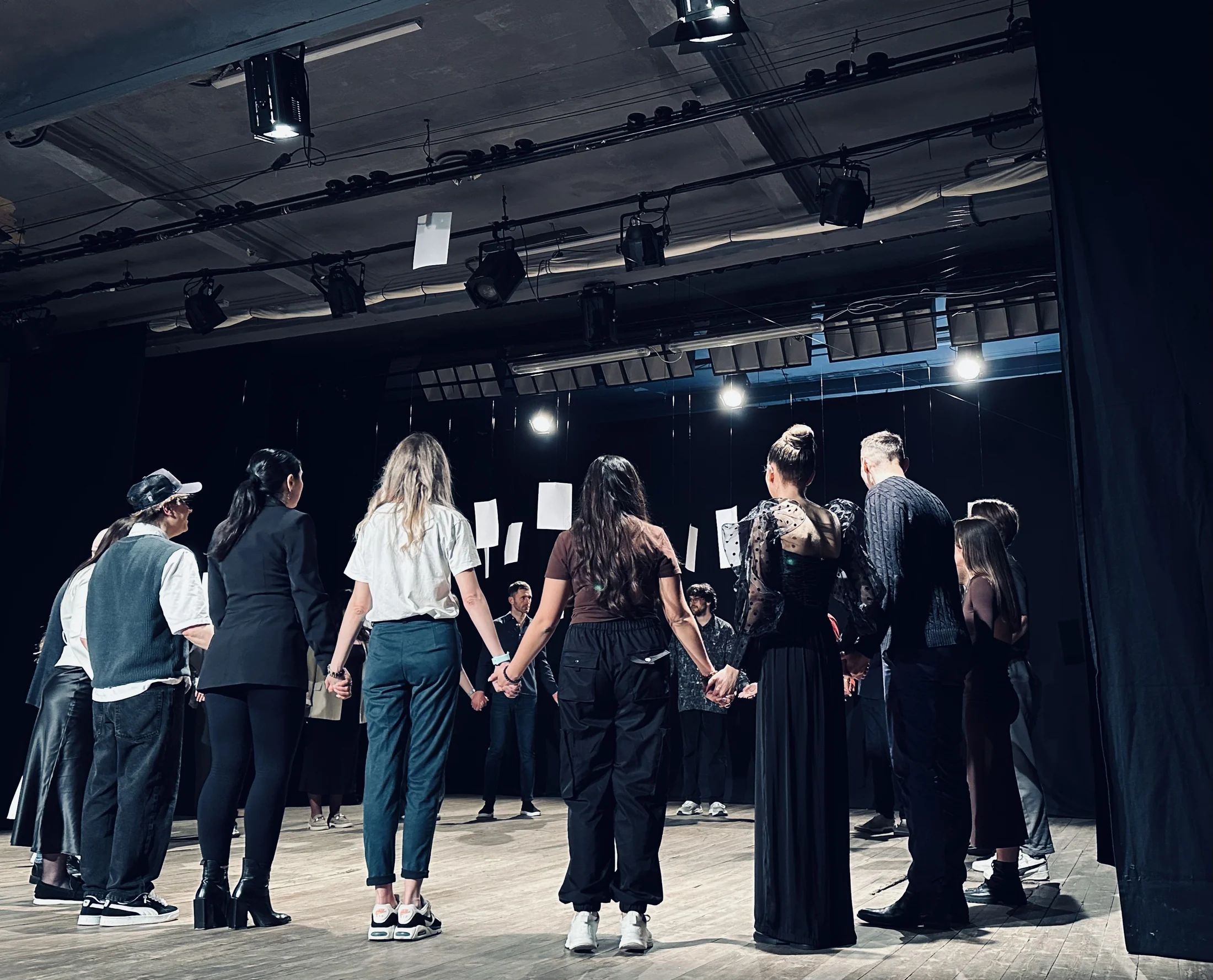 Participanți lucrând în spațiul liber al unei săli de teatru.
